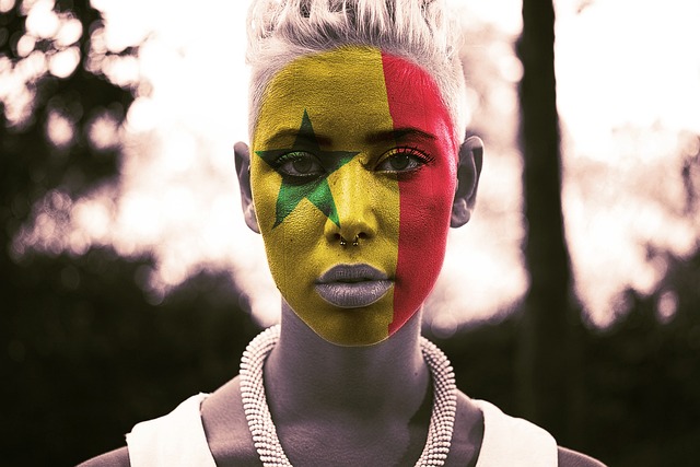 Mujer con la cara pintada con la bandera de Senegal